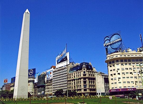 The Obelisk (El Obelisco) along Nueve de Julio Avenue in Buenos Aires. The thoroughfare, named after Argentina's independence day (9 July 1816), is generally considered the widest avenue in the world. The Obelisk, built in 1936, measures 67 meters high (220 feet) and commemorates the founding of the city.