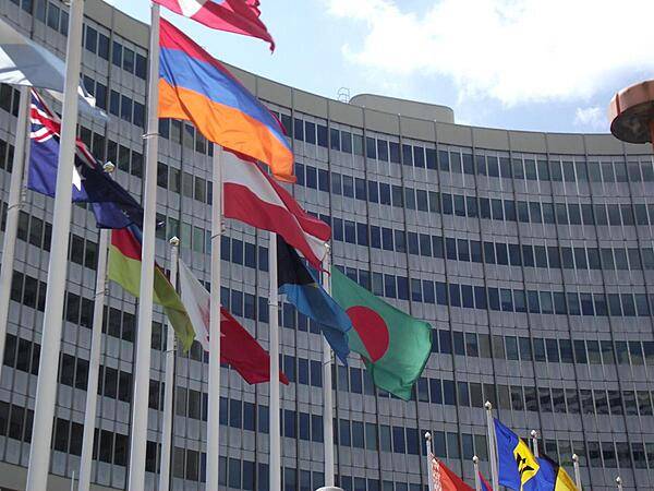The red-white-red flag of Austria flies with those of all the other UN countries in the entrance plaza of the United Nations Office in Vienna.