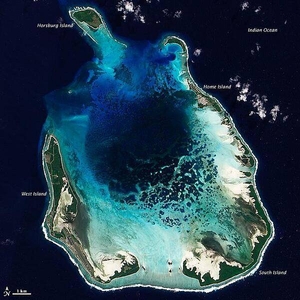 The Cocos (Keeling) Islands lie in the eastern Indian Ocean, about 2,900 km (1,800 mi) northwest of the Australian city of Perth. Comprised of coral atolls and islands, the archipelago includes North Keeling Island and the South Keeling Islands. This natural-color satellite image of the South Keeling Islands dates to 31 July 2009.

Coral atolls - which are largely composed of huge colonies of tiny animals - form atop islands. Over time the islands may subside, but the coral remains growing upward and generally forming complete or partial rings. Only some parts of the South Keeling Islands still stand above the water surface. In the north, the ocean overtops the coral.

Along the southern rim of this coral atoll, the shallow water appears aquamarine. The water darkens to navy blue as it deepens toward the central lagoon. Above the water line, coconut palms and other plants form a thick carpet of vegetation.

In 2005, the Australian Government issued a report on the Cocos (Keeling) Islands, summarizing field research conducted between 1997 and 2005. Overall, the report noted, "the coral reef community at Cocos (Keeling) Islands is very healthy and in a stable period, with little impact from anthropogenic activities." Image courtesy of NASA.