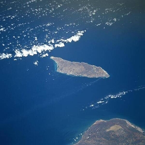 Aruba is a semi-arid island that experiences little variation in temperature throughout the year. Rainfall, which occurs mostly in November and December, averages less than 50 cm (20 in) a year. The red soil on the island is poor and thin and the thorny vegetation is quite drought resistant. Tourism and the refining of oil brought in from nearby Venezuela (whose northern coast appears below) are the major industries. Oraniestad, located on the northwest coast, is the major city of the island. Image courtesy of NASA.