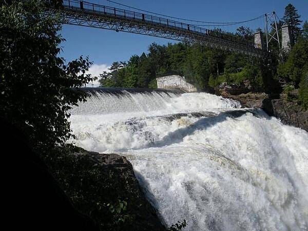 The Montmorency Falls form at the mouth of the Montmorency River as it drops over a cliff shore into the St. Lawrence River. The falls are the highest in the province of Quebec.