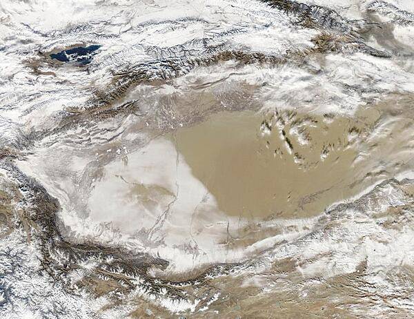 Snow-covered deserts are rare, but that is exactly what NASA's Aqua satellite observed as it passed over the Takla Makan Desert in the Xinjian Uygyr autonomous region of western China on 2 January 2013. The Takla Makan is one of the world's largest and hottest sandy deserts. Water flowing into the Tarim Basin has no outlet so, over the years, sediments have steadily accumulated. In parts of the desert, sand can pile up to 300 m (roughly 1,000 ft) high. The mountains that enclose the sea of sand - the Tien Shan in the north and the Kunlun Shan in the south - are also covered with what appears to be a significantly thicker layer of snow. Image courtesy of NASA.