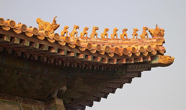 Roof charms decorate a building in the Forbidden City. The more important the structure, the more decorative charms were used - in this case eleven: a man riding a phoenix heads a procession of nine mythical beasts that are followed by an imperial dragon.