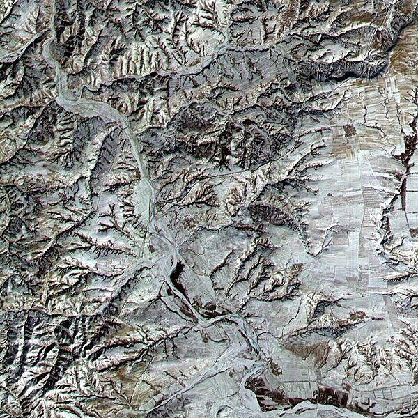 An area in northern Shanxi Province imaged on 9 January 2001. The low sun angle and light snow cover highlight a section of the Great Wall, visible as a black line snaking diagonally through the image from lower left to upper right. The Great Wall (actually a series of walls) is over 2,000 years old and was built over a period of 1,000 years. Stretching 8,850 km (5,500 mi) from Korea to the Gobi Desert, it was built to protect China from northern marauders. Click on photo for higher resolution. Image courtesy of NASA.