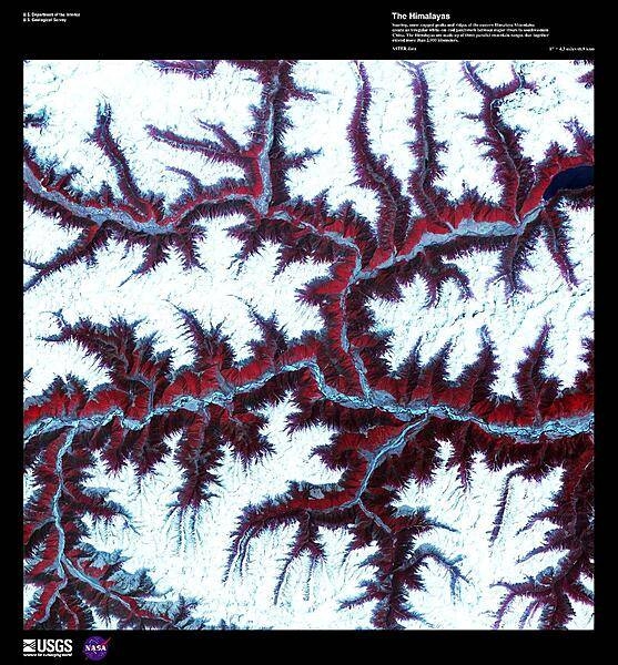 Soaring, snow-capped peaks and ridges of the eastern Himalaya Mountains create an irregular white-on-red patchwork between major rivers in southwestern China in this enhanced satellite image. The Himalayas are made up of three parallel mountain ranges that together extend more than 2,900 km (1,800 mi) and are the youngest mountain range on the planet. Some of the world's major rivers rise in these mountains and their combined drainage basin is home to almost half of the world's entire population. Image courtesy of USGS.