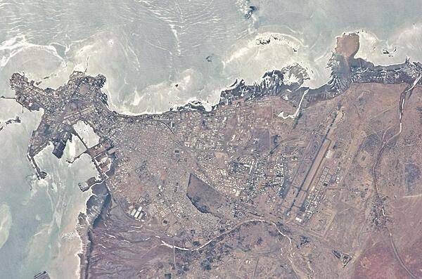 Djibouti City is the capital and largest city in Djibouti. Two thirds of the country's population lives in this seaport, which is situated on the Gulf of Tadjoura on the western side of the Gulf of Aden. The city is the cultural and industrial center of Djibouti and has the status of both a city and a state. Local features include beautiful sandy beaches along its eastern shore (top). The landscape around the city, along with Djibouti's coastal lowlands, is desert or semi-desert. Image courtesy of NASA.