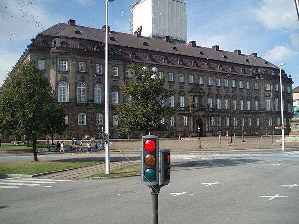 Side view of Christiansborg Palace on the island of Slotsholmen in central Copenhagen. The structure serves as the seat of the Folketinget (Danish parliament), the prime minister's office, and the Danish Supreme Court. It is the only building in the world where all three branches of government - the executive, legislative, and judicial - are housed in one building.