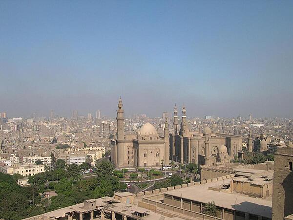 The Sultan Hassan and Ar-Rifai Mosques as seen from the Citadel with Cairo in the background. The Sultan Hassan Mosque and Madrasah (religious school) is a masterpiece of Mamluk architecture that was begun in 1356 and completed in 1363. It contains the burial chamber of the Sultan's two sons and is featured on the Egyptian hundred-pound note. The Ar-Rifai Mosque was built between 1869 and 1912. It houses the tomb of King Farouk, Egypt's last reigning monarch, and other members of the Egyptian royal family, as well as the tomb of the last shah of Iran.