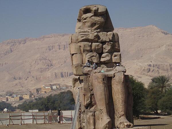 One of a pair of 30-meter (50-ft) statues of Amenhotep III that once stood before the pharaoh's mortuary temple in the Theban Necropolis on the west bank of the Nile opposite Luxor. The rest of the temple was dismantled, and the materials used for other construction projects. The statues were called the "Colossi of Memnom" by Egypt's late Ptolemaic (Greek) rulers who associated them with the myth of Memnon.