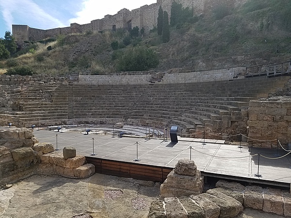 Remains of a Roman amphitheater in Malaga. Some Roman building materials were used in constructing the Alcazaba (Moorish castle complex), which may be seen in the background.