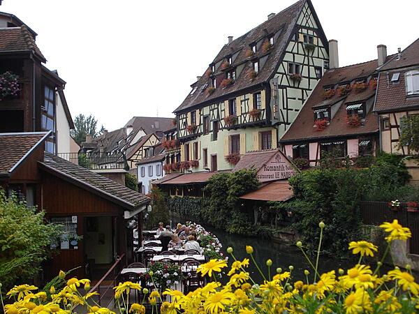A cafe on a canal in Colmar. The town, situated on the Alsatian Wine Route, was founded in the 9th century. In 1226, it became a Free Imperial City of the Holy Roman Empire. It was conquered by Louis XIV and the French in 1673 and over subsequent centuries alternated between German and French control. It reverted to France in 1945.