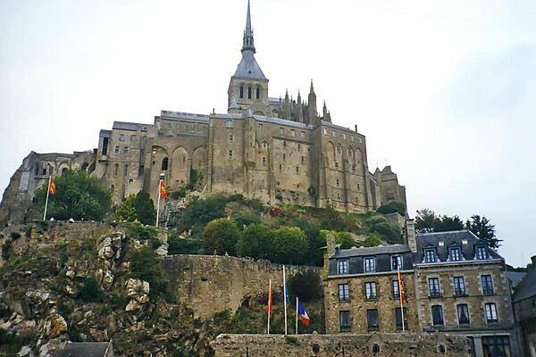 The fortified island abbey of Mont-Saint-Michel off the coast of Normandy. At one time the site was disconnected from the coast at high tide, but silting has since connected the island to the mainland. Today, an operation is underway to desilt the area around the island. It was not until the 8th century that the first monastic establishment appeared on the island. Before that it was a stronghold of Romano-Breton culture and power. In the Hundred Years War, the French successfully prevented the English from capturing the island. During the Reformation, the popularity of the Mont declined, and during the French Revolution it became a prison which finally closed in 1863. In 1874, Mont-Saint-Michel was declared a historic monument; in 1979, it became a UNESCO World Heritage Site.