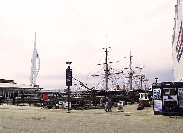 HMS Warrior docked in Portsmouth Harbor, England. The city's iconic Spinnaker Tower, opened in 2005, appears at the left. The tower's height is 170 m (560 ft); it has three viewing decks at 100-, 105-, and 110-meter levels.