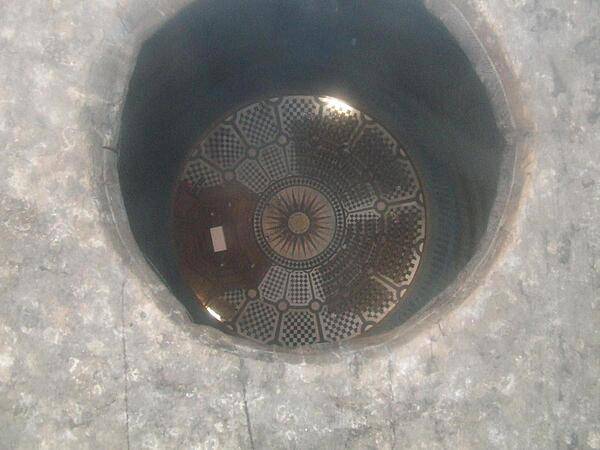View through a circular cut opening (glass covered) down onto the crossing under the dome of St. Paul's Cathedral in London.