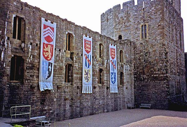 Heraldic banners decorate the walls of Caernarfon Castle, Wales, constructed by King Edward I following the conquest of Gwynedd. Begun in 1283, it reached it current state in 1323, but was never entirely completed.