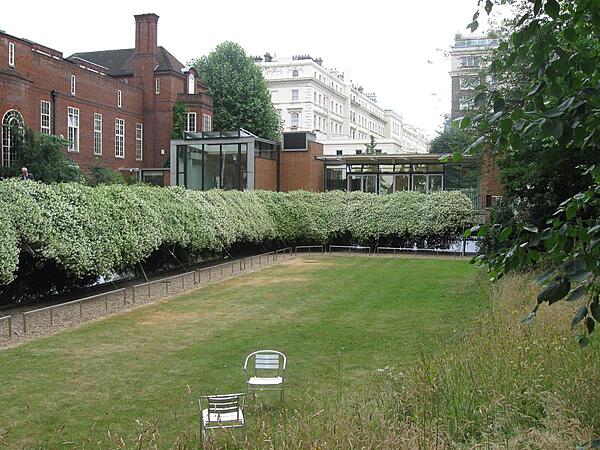 The new glass Pavilion exhibition space of the Royal Geographical Society (RGS) opened in 2004 behind Lowther Lodge, the society's main building. Beneath the Pavilion and to the foreground is the Foyle Reading Room and the RGS library, which are covered by a sunken lawn, but which receive illumination through the bush-shaded skylights.