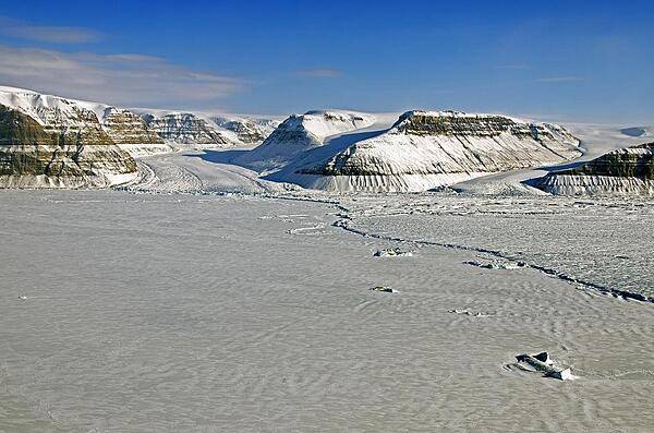 The calving front of Petermann Glacier in northern Greenland as seen from a NASA P-3B. In July 2012 an iceberg twice the size of Manhattan broke off of Petermann Glacier and began to float away in the ocean. After this calving event the line where the iceberg broke away became the glacier's new front edge, or calving front, effectively moving it several kilometers upstream. Credit: NASA/Michael Studinger.