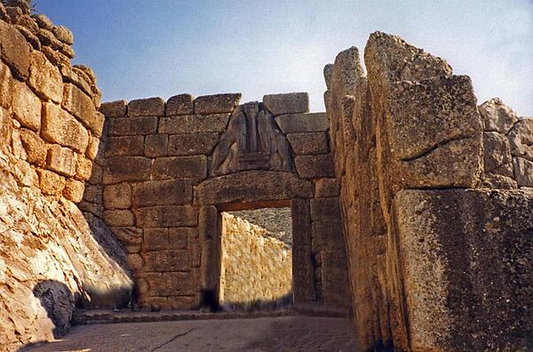 The Lion Gate at the Late Bronze Age site of Mycenae. The archeological site is located 90 km (55 mi) southwest of Athens on the Peloponnesian Peninsula. Agamemnon, Clytemnestra, and Orestes all reputedly lived in the royal palace of the fortified city.