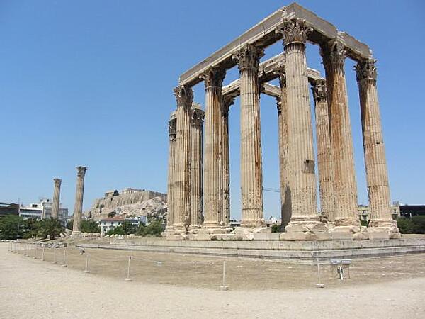 The Temple of Olympian Zeus (Olympieion) in Athens. Construction began in 520 B.C. but was not completed until A.D. 132 in the reign of Roman Emperor Hadrian. Sixteen of the original Corinthian 104 columns survive (15 standing, one fallen). The Acropolis can be seen in the distance.