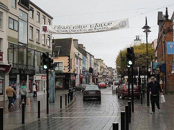 Street view of Killarney, County Kerry. Killarney is one of the principal towns in the country and a center of tourism for the region. The sign over the street reads "A Hundred Thousand Welcomes" (Cead Mille Failte).