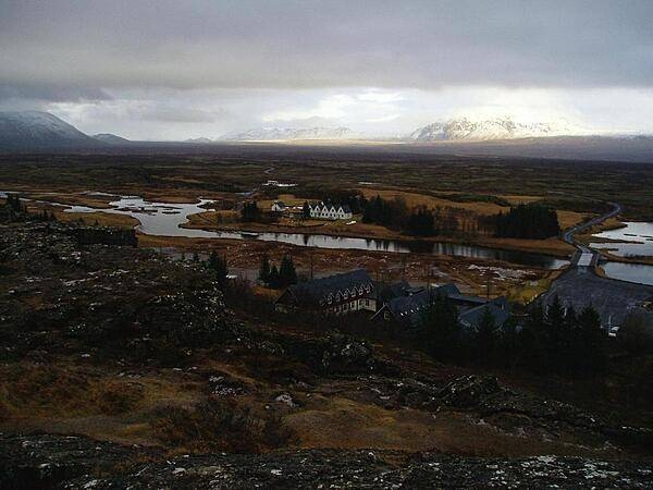 Photo taken from the Eurasian continental plate (foreground rock ledge) looking across to the North American plate and to the Thingvellir, the plains on which the Icelandic republic was founded in 930 and independence declared in 1944. The tabletop mountain on the horizon was formed by a volcanic eruption beneath a glacial ice sheet when Iceland was covered by ice.