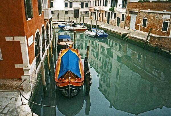 Moored boats along a quiet Venetian canal.