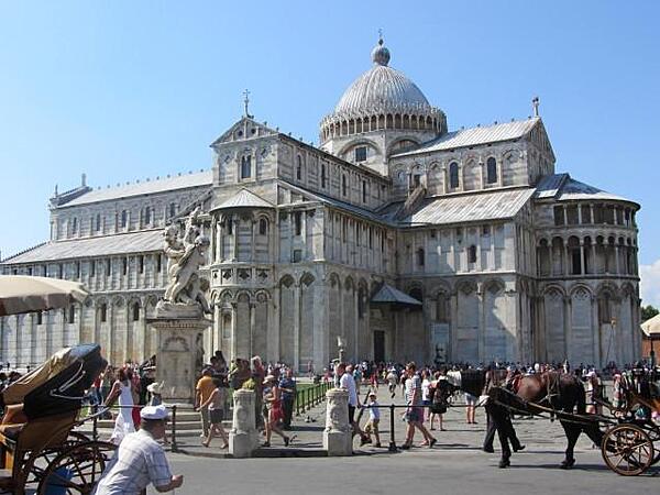 Side view of the Cathedral of Santa Maria of the Assumption in Cathedral Plaza in Pisa. It was built in Pisan Romanesque style by the master Rainaldo using gray marble and white stone.
