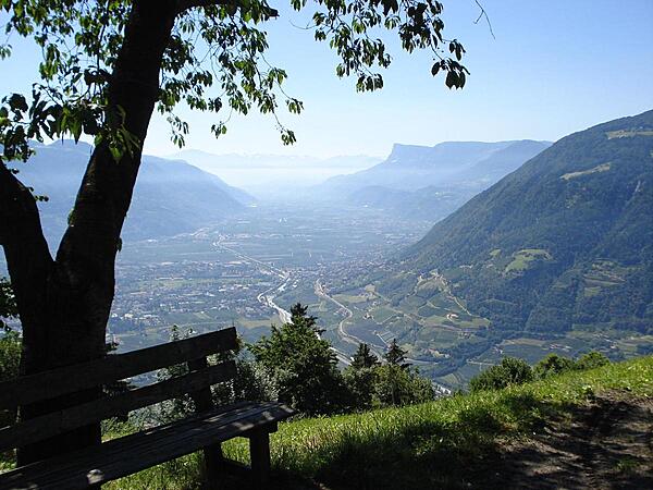 A scenic view of the town of Meran nestled in the mountains.