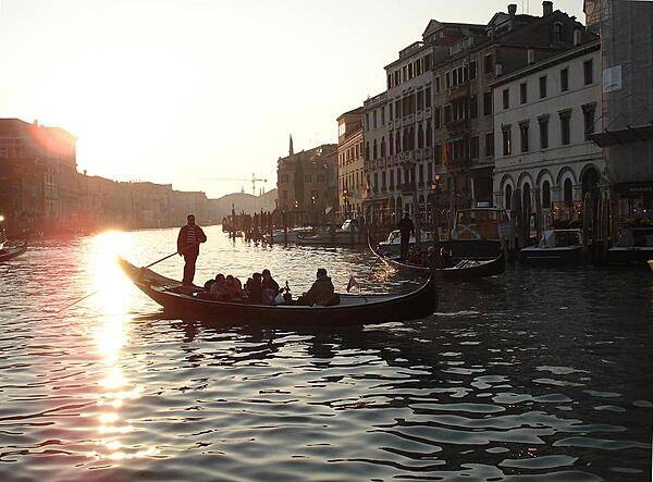 Gondolas on the Grand Canal. A gondola is a traditional flat-bottomed Venetian rowing boat, hand-made using eight different types of wood and composed of 280 pieces.