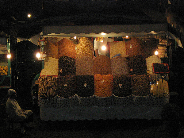A night market vendor in Jemaa el-Fna - the main square in Marrakech - selling dried fruit and nuts.