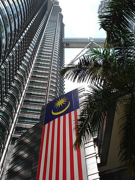 Looking up one of the Twin Towers to the double-decker walkway. A Malaysian national flag hangs hear the entrance.