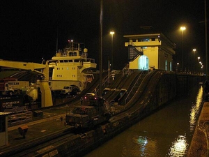 A view of the Panama Canal at night, including one of the locks buildings and a "mule," one of the trains that pull ships through the locks.