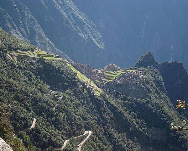 This panaramic view highlights the steep hills that buses and hikers traverse to reach the ruins.