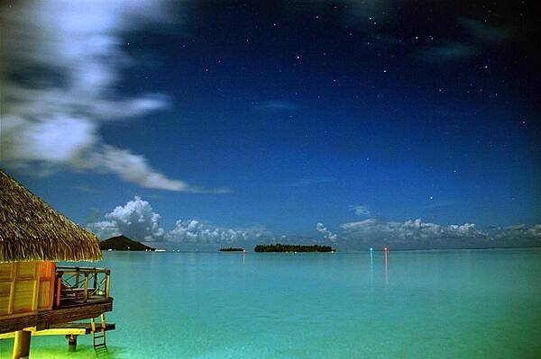 Nightfall over an over-water bungalow in Bora Bora.