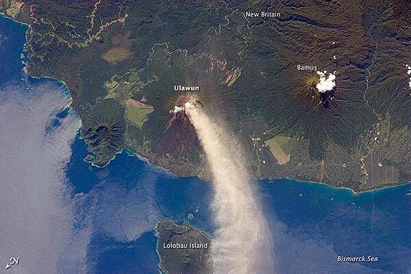 Numerous volcanoes contribute to the landmass of the island of New Britain, the largest in the Bismarck Archipelago of Papua New Guinea. One of the most active of these volcanoes - Ulawun - is also the tallest, with a summit elevation of 2,334 m (7,657 ft).

This astronaut photograph shows a plume of white steam and ash extending from the summit crater of the stratovolcano towards the northwest. The plume begins to broaden as it passes the southwestern coast of Lolobau Island, approximately 23 km downwind. Note that north is towards the lower left.

Ulawun is also known as "the Father," with the Bamus volcano to the southwest also known as "the South Son." The summit of Bamus is obscured by white cumulus clouds (not of volcanic origin) in this image. While Ulawun has been active since at least 1700, the most recent activity at Bamus occurred in the late 19th century. A large region of ocean surface highlighted by sunglint - sunlight reflecting off the water surface - is visible to the north-northeast of Ulawun. Photo courtesy of NASA.