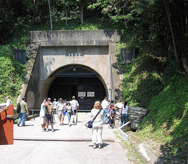 East entrance to the Malinta Tunnel complex on the island of Corregidor. Constructed by the US Army Corps of Engineers between 1922 and 1932, it was used for bomb-proof storage, as a command center, and a 1,000-bed hospital. The main east-west tunnel is 253 m (830 ft) long and 7.3 m (24 ft) wide, with 24 lateral tunnels, each about 49 m (160 ft) long and 4.6 m (15 ft) wide. A double track electric railway ran down the main tunnel. General Douglas MACARTHUR's headquarters and the offices of President Manuel L. QUEZON of the Philippines Commonwealth were located in laterals just inside this entrance.