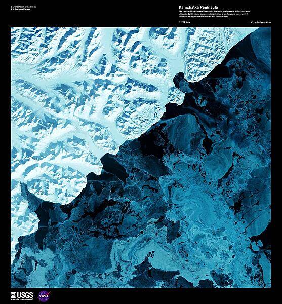 The eastern side of the Kamchatka Peninsula juts into the Pacific Ocean west of Alaska in this enhanced winter satellite image. Snow-covered peaks and valley glaciers feed blue ice into coastal waters. The Kamchatka Peninsula is home to 160 volcanoes, 29 of which are active. The Volcanoes of Kamtchaka together form a UNESCO World Heritage Site. For other active volcanoes in Russia, see the Natural hazards-volcanism subfield in the Geography section. Image courtesy of USGS.