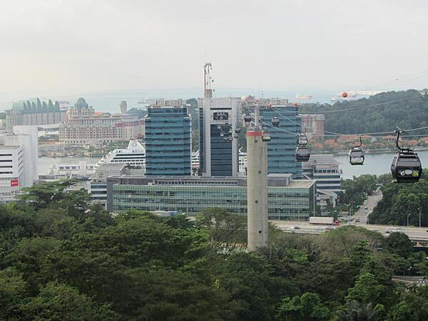 View from Mount Faber of cable car system connecting mainland Singapore to Sentosa Island. The Marine Terminal and cruise ships may be seen in the middle ground. The cable cars run through the middle tower in the terminal.