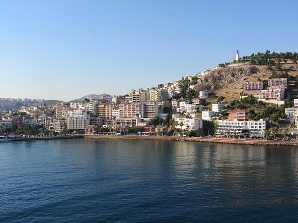 View of the port of Kusadasi on the Aegean Sea. The name Kusadasi means "Bird Island." In Byzantine times it was called "Ephesus Neopolis" and "Scala Nova" under the Genoese and Venetians. Its current name was officially adopted at the beginning of the 20th century by Turkish authorities. Kusadasi is the gateway to the Roman ruins at Ephesus. Some 95 km (57 mi) south of Izmir, it has grown since the late 1970s from a fishing village into a major tourist center serving thousands of tourists. A statue of Kemal Ataturk, the first president of Turkey and the founder of the Turkish Republic, stands on a hill overlooking the city.