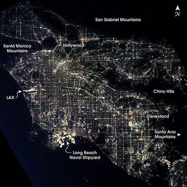 Los Angeles at night as seen from the International Space Station. After sunset, the borders of "The City of Angels" are defined as much by its dark terrain features as by its well-lit grid of streets and freeways. Over 13 million people inhabit the coastal basin bounded roughly by the Santa Monica and San Gabriel Mountains to the north and the Chino Hills and Santa Ana Mountains to the east and southeast. Image courtesy of NASA.