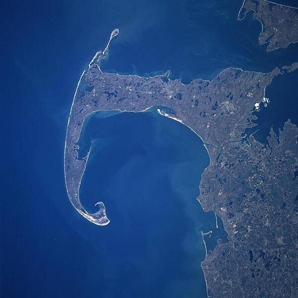 Cape Cod and Cape Cod Bay (visible at the center of the image) can be seen in this generally south-looking view. Cape Cod is a narrow peninsula, glacial in origin, that is constantly changing as winds and water move sand along the shoreline. Cape Cod extends 105 km (65 mi) east and north into the Atlantic Ocean. A portion of Martha's Vineyard may be seen in the upper right corner of the image. Photo courtesy of NASA.