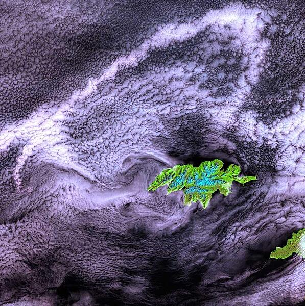 As the westernmost point in North America, Attu is a rugged island dominated by snow-covered mountains (blue in this false-color photo). It is 32 by 56 km (20 by 35 mi) and lies at the far western end of the Aleutian chain, approximately 1770 km (1100 mi) from the Alaskan mainland and 402 km (250 mi) from the Siberian coastline. The weather is characterized by persistently overcast skies, fog, high winds, and frequent cyclonic storms. The Japanese invaded and occupied Attu in June 1942. Today, the island is home to a US Coastguard station and is a sanctuary to many of North America's rarest birds. Image courtesy of NASA.