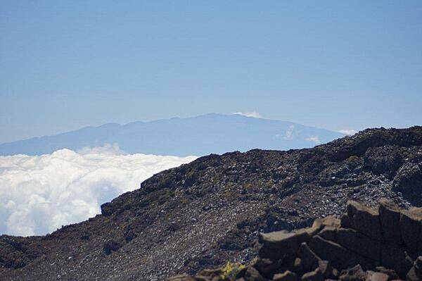 A vista from the visitors center at the top of Haleakala in Maui. In the distance, 130 km (80 mi) away, lies the peak of Mauna Kea on the big island of Hawaii.