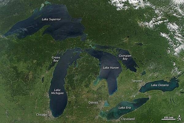 This image is a rare satellite view of a cloudless summer day over the entire Great Lakes region. The Great Lakes comprise the largest collective body of fresh water on the planet, containing roughly 18 percent of Earth's supply. Only the polar ice caps contain more fresh water. The region around the Great Lakes basin is home to more than 10 percent of the population of the United States and 25 percent of the population of Canada.
Open water appears blue or nearly black. The pale blue and green swirls near the coasts are likely caused by algae or phytoplankton blooms, or by calcium carbonate (chalk) from the lake floor. Photo courtesy of NASA.