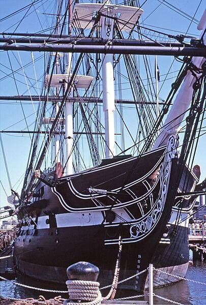 Close up view of the bow of the USS Constitution. The ship is constructed of white and longleaf pine, white oak, and, most importantly, southern live oak. The latter is particularly dense, heavy, and difficult to work, but very strong. Because her hull was built 53 cm (21 in) thick in an era when 47 cm (18 in) was common, she was able to withstand cannonades, thus earning the nickname of "Old Ironsides." The copper sheathing along the keel prevents the attachment of shipworms.