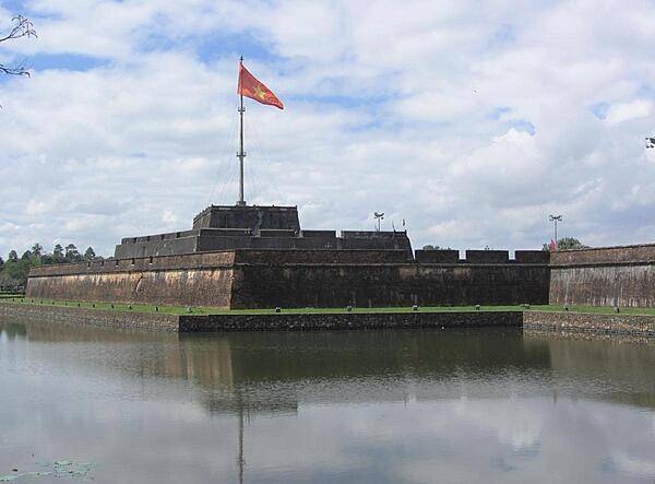 Flag tower in Hue, the former imperial capital of Vietnam. Located on the Perfume River in central Vietnam, Hue was the capital of Vietnam from 1802 until 1945. A walled citadel, 2 km by 2 km, as well as a moat, surrounded the city. Inside the citadel was the Imperial City. Many of the buildings of the Imperial City were destroyed during the Vietnam War. Some reconstruction has begun.