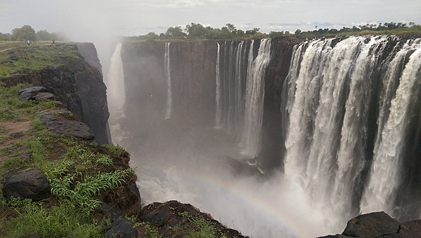 Sunlight penetrating the mist thrown up at Victoria Falls can create rainbows. The power, height, and majesty of the falls are all evident in this scene.